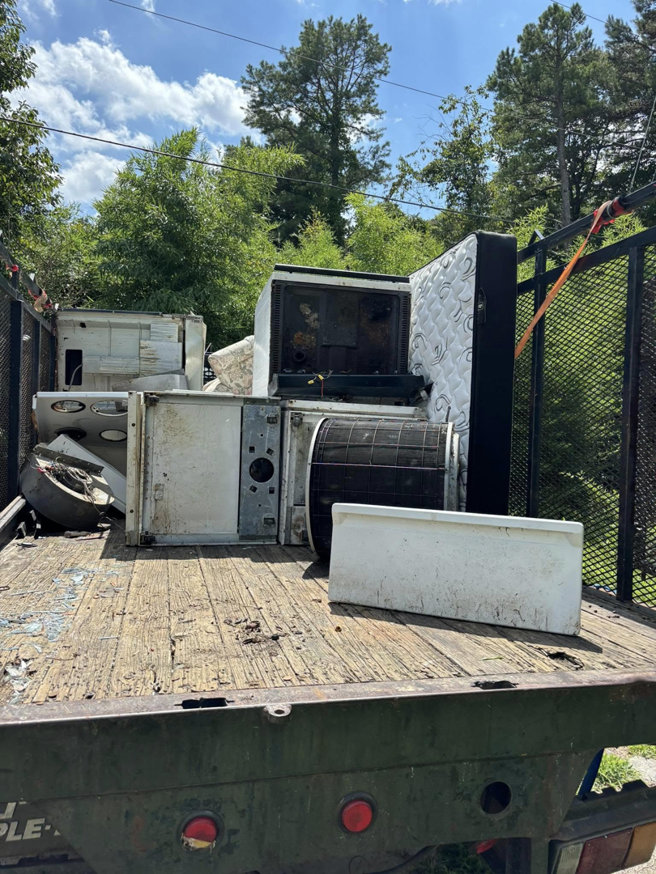 A truck loaded with old appliances, a mattress, and debris for junk hauling by Allen's Junk Removal & Hauling in Smyrna, TN.