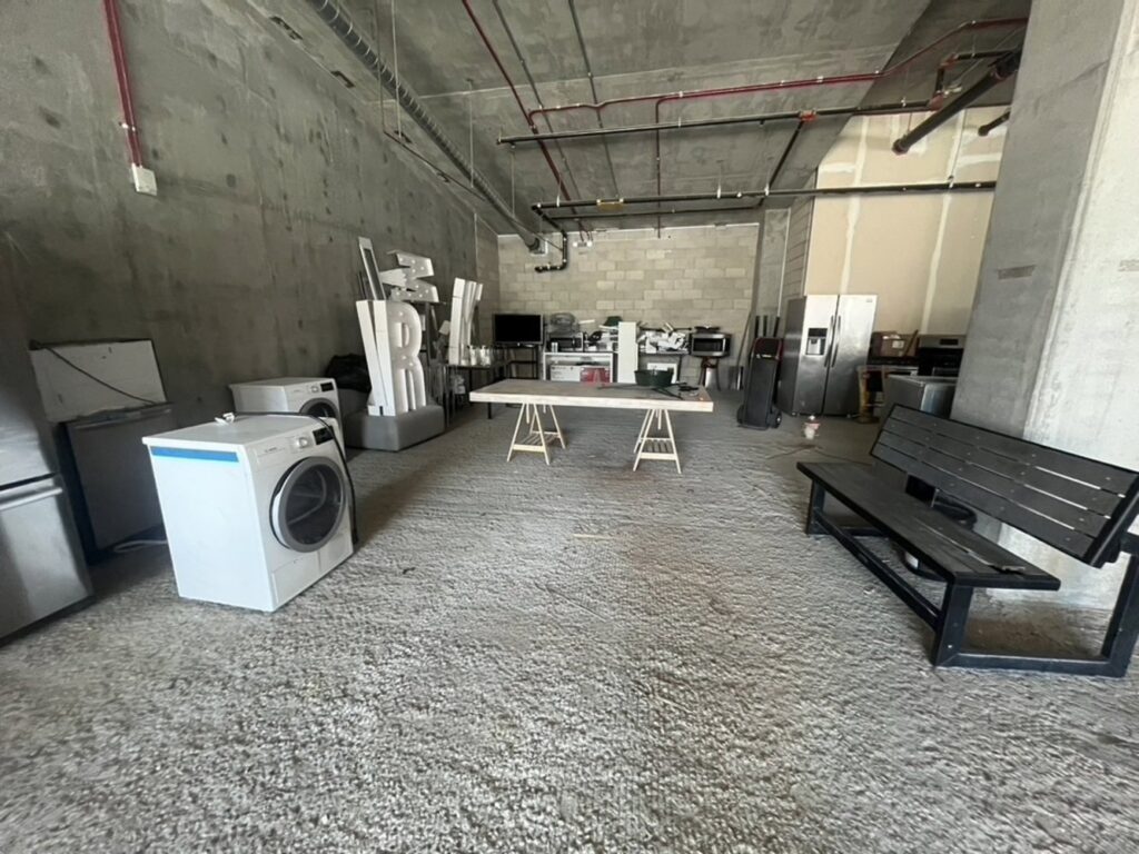 Large appliances like washers, dryers, and refrigerators in a commercial space, ready for removal by L.A. Junk Squad in Bell Gardens, CA.