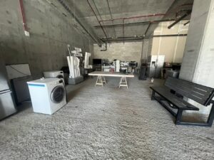 Large appliances like washers, dryers, and refrigerators in a commercial space, ready for removal by L.A. Junk Squad in Bell Gardens, CA.