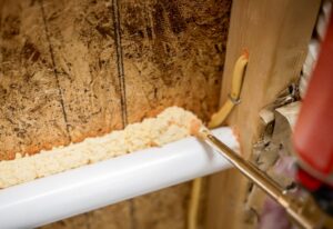 A close-up of a technician applying spray foam insulation to seal gaps by Koala Insulation of Charlotte, NC