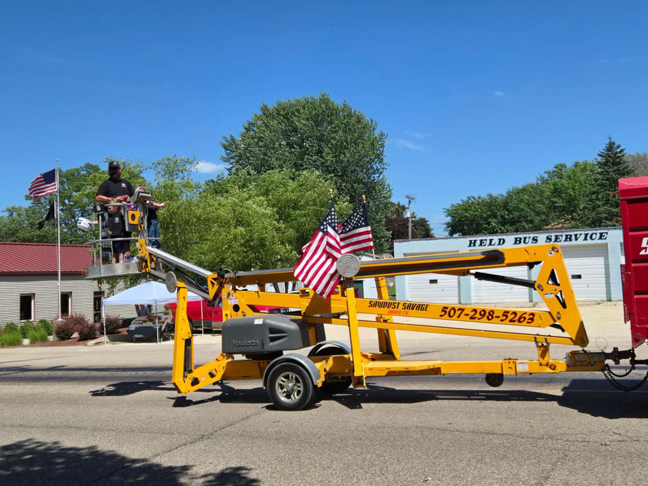 Arborists operating an aerial lift for tree trimming services by Sawdust Savage Arbor Co. LLC in Rochester, MN.