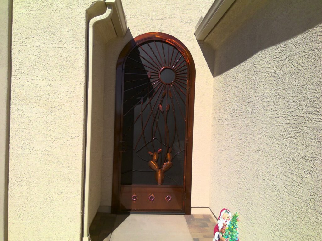 An arched security screen door with a sunburst and deer design installed by Affordable Fence & Gates in Tucson, AZ.