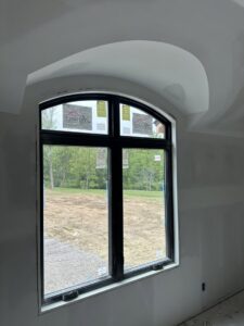 Detailed drywall finishing around an arched window completed by Hahn Brothers Drywall Co Inc in Evansville, IN
