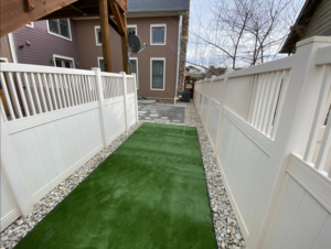 Artificial turf and white vinyl fence installation in a side yard by GKC Landscaping Contractors in Thornton, CO.