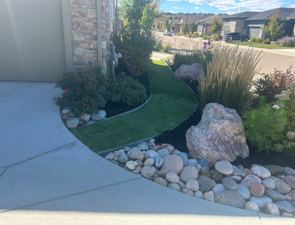 Completed artificial turf pathway and rock landscaping by Blue Collar Service Pros in Aurora, CO.