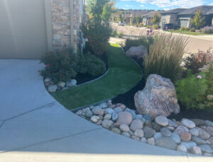 Completed artificial turf pathway and rock landscaping by Blue Collar Service Pros in Aurora, CO.