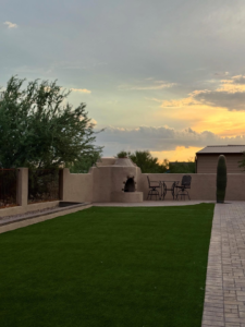 A backyard featuring artificial turf and a paved pathway installed by Oakswood Turf and Hardscape in Tucson, AZ