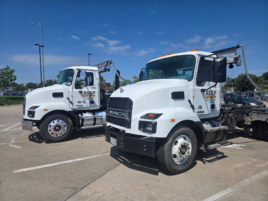 An ASAP Containers inc. truck delivering a blue dumpster to a residential driveway for junk removal in Omaha, NE.