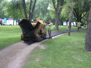 A crew from Buck Blacktop Inc performing asphalt paving work on a path in Little Canada, MN.