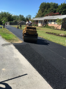 Workers using a roller for asphalt paving on a driveway by Free State Contracting Company in Annapolis, MD