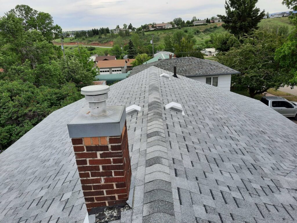 Gray asphalt shingle roof with a brick chimney and vents by RC Contracting in Chesterfield, MO.