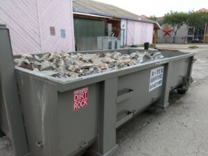 An ATEX Dumpsters Services roll-off dumpster filled with concrete and tile debris in Austin, TX.