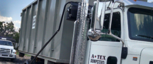 An ATEX Dumpsters Services truck with a roll-off dumpster ready for junk removal in Austin, TX.