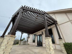 Construction of an attached wooden pergola with a ladder visible by Oklahoma Painting & Construction in Oklahoma City, OK.