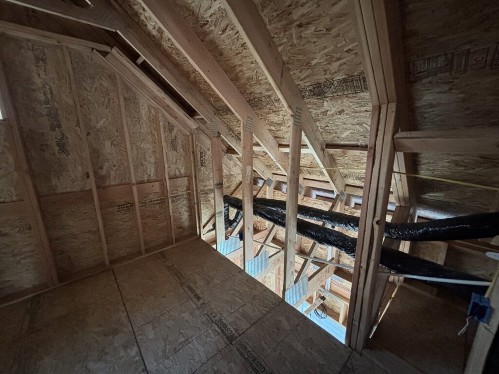 An attic space showing exposed wooden framing and ductwork, often inspected by Pacific Insulation & Mold Remediation in Spokane, WA.