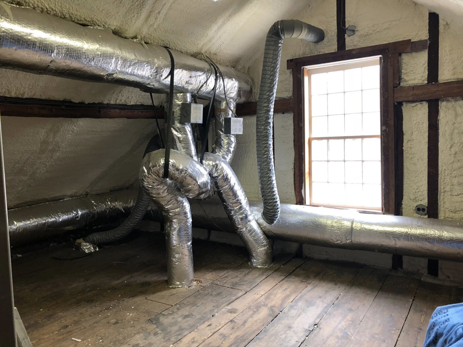 Attic space showing spray foam insulation and extensive ductwork installed by Safco Foam Insulation in Hampden, MA.