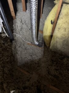 An attic with existing loose insulation and a flexible duct, ready for inspection or upgrade by Pacific Insulation & Mold Remediation in Spokane, WA.