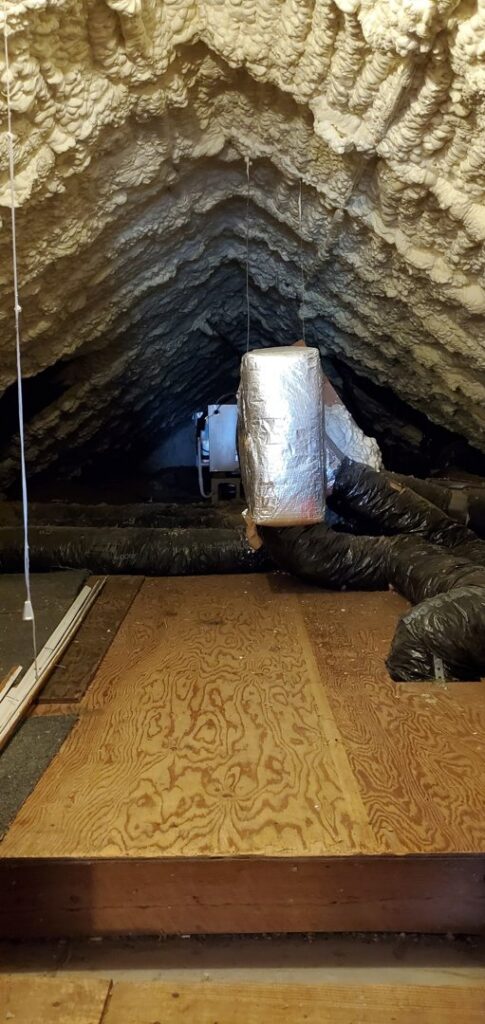 Attic space with extensive spray foam insulation applied to the roofline and around ductwork by Spray Foam Solutions Of Erie in Erie, PA.