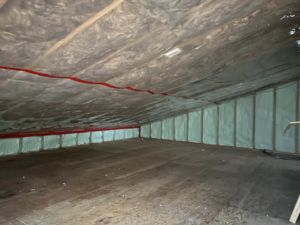 Attic insulation installation with spray foam and a vapor barrier by Haus Builders in Goodhue, MN