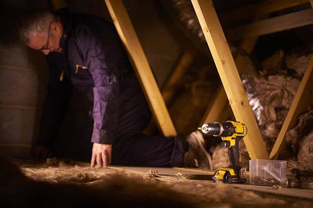 A handyman installing insulation in an attic, a service provided by Hollywood Handyman in Glendale, CA.