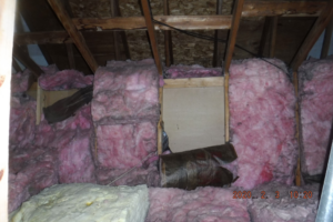 Pink fiberglass insulation installed in an attic space, demonstrating handyman services by Hometrust Remodeling in Baltimore, MD.