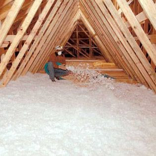 A worker installing new insulation in an attic for Our Place Air & Home Repair in Orlando, FL.