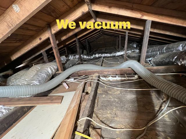 A handyman vacuuming old insulation from an attic for Architectural Insulation in Lake Charles, LA.