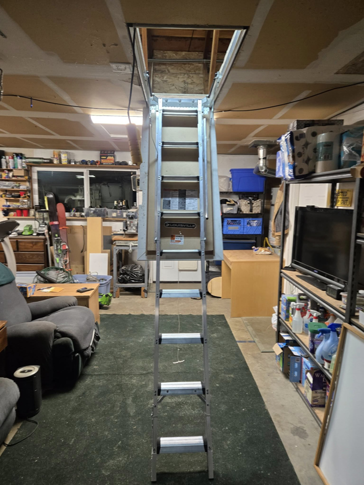 A newly installed attic ladder extending into a garage, completed by Hands On Repair in Renton, WA.