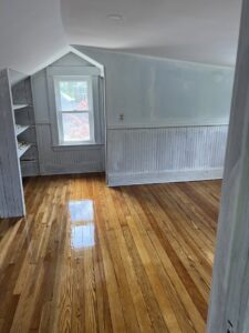 Attic room with newly finished hardwood floor and beadboard paneling by Diamond Flooring LLC in Boston, MA