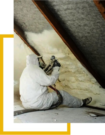 Worker applying spray foam insulation in an attic space for CT Insulation Services LLC in Stamford, CT