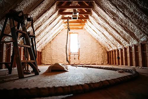 An attic space with newly installed spray foam insulation by Custom Insulation Company, Inc. in Worcester, MA