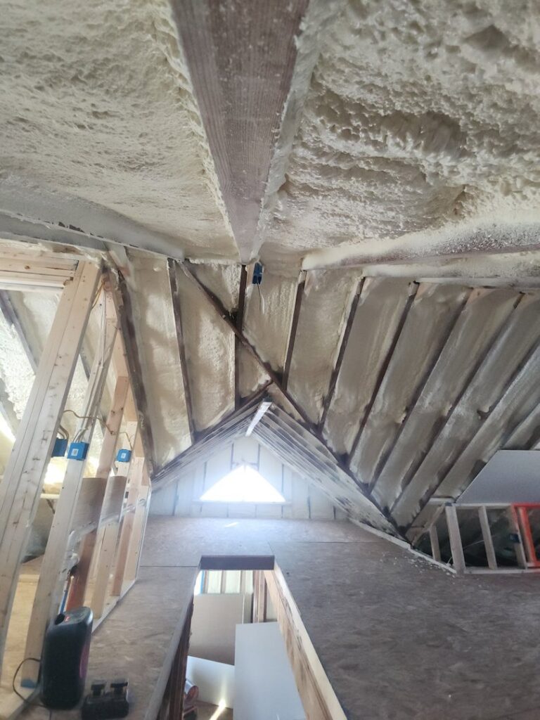 Attic space showing new spray foam insulation installation by FG Drywall, Finishing and Painting in Champaign, IL.