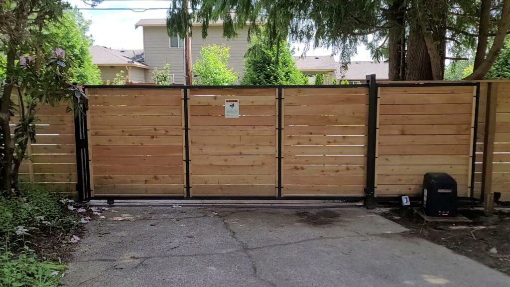 A newly installed automatic wooden sliding gate with a metal frame by LMS Landscapes & Fence services in Auburn, WA.