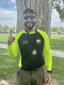 An award-winning tree climber and arborist from My Tree Guys, LLC, proudly displaying his medal in Salt Lake City, UT.