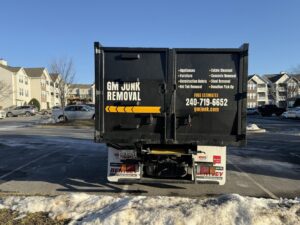 The back of a GM Junk Removal truck listing services and contact information in Frederick, MD.