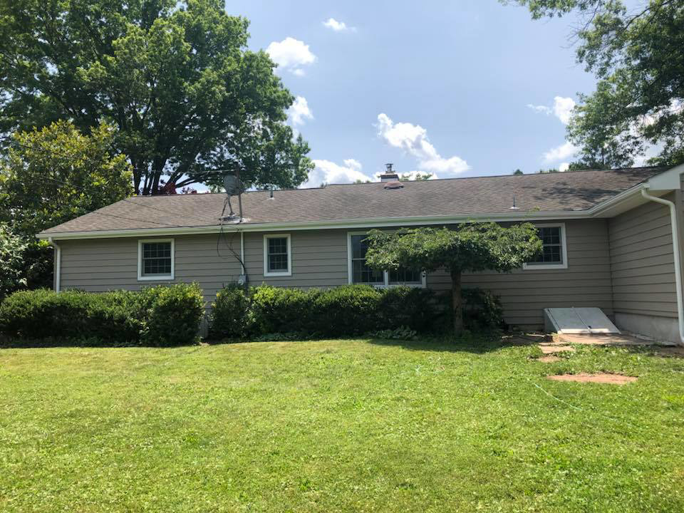 The back of a house featuring new siding and a new roof, showcasing work by Quality Care Home Improvements in Hamilton, NJ.