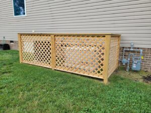 A newly installed black metal fence with decorative rocks in a residential backyard by Minors Fences in Ashland, VA.