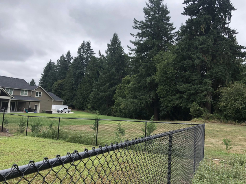 A black chain-link fence enclosing a backyard area installed by J & M Fence Co. in Vancouver, WA.