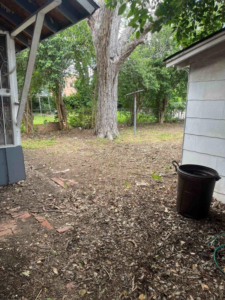 A backyard area with leaves and debris, indicating a cleanup job for Silverhull Junk Removal in San Antonio, TX