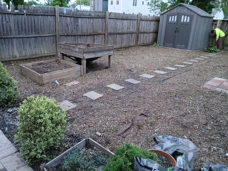 A person performing backyard cleanup and maintenance near a shed by Isac's General Services LLC in Henrico, VA