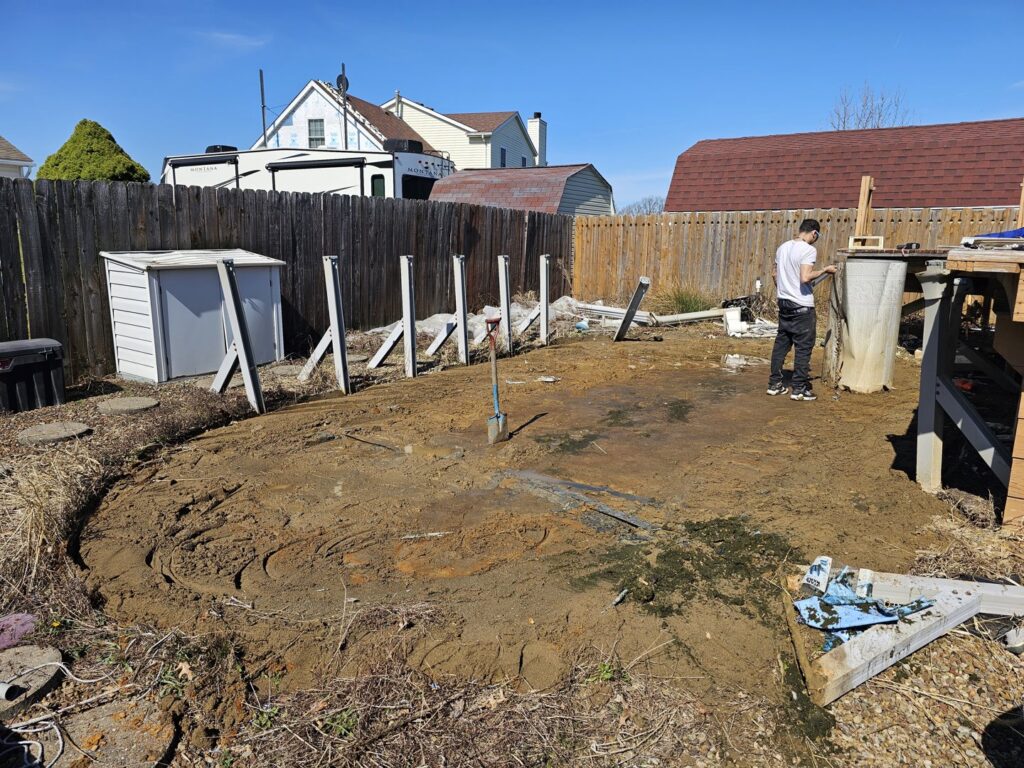 A backyard undergoing clearing with scattered debris, indicating a junk removal job by T&G Dumping in Lorain, OH.