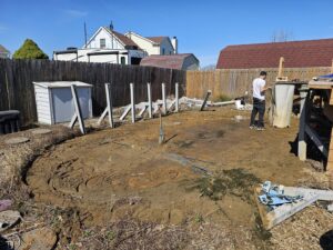 A backyard undergoing clearing with scattered debris, indicating a junk removal job by T&G Dumping in Lorain, OH.