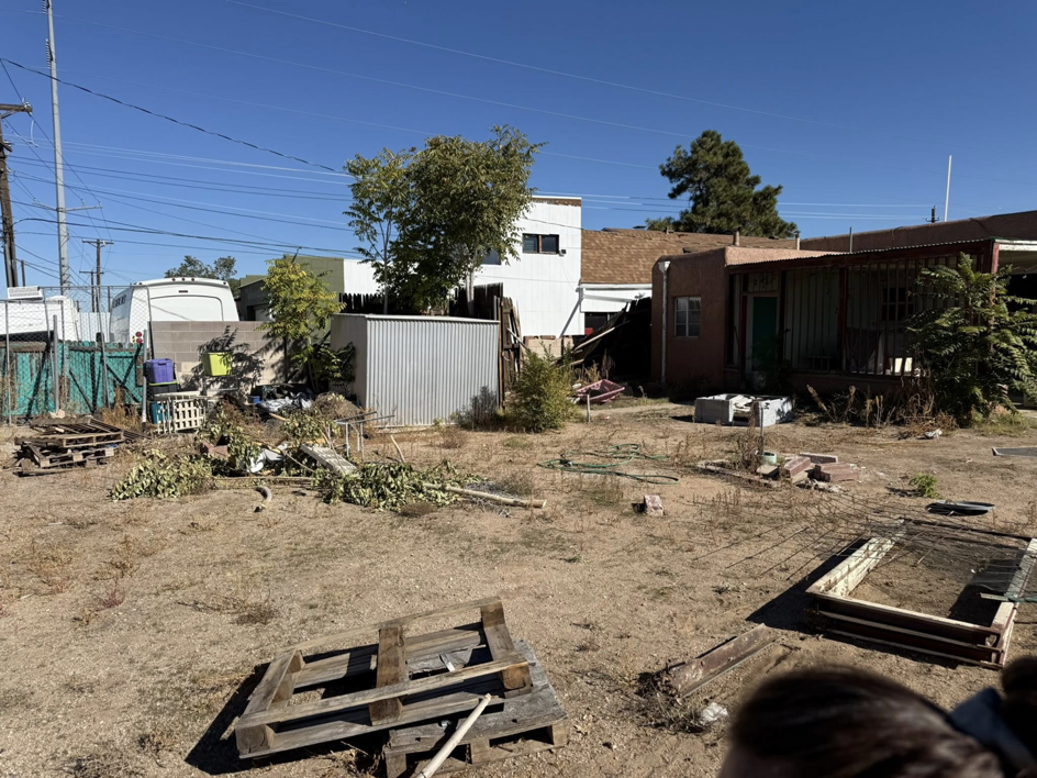A backyard with scattered branches and debris on the ground after tree trimming by Green Peak Landscaping LLC in Kaysville, UT.