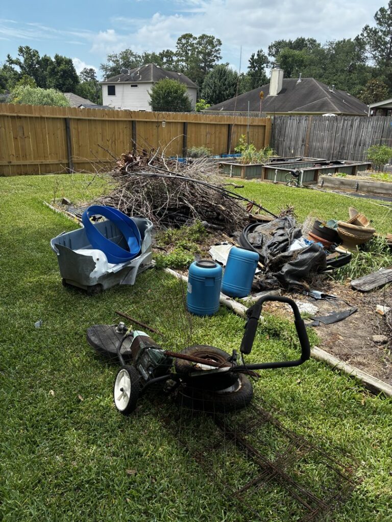 A backyard with a large pile of branches, old equipment, and yard waste, ready for Handymen Junk Removal in Houston, TX.