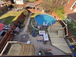 An aerial view of a backyard featuring new wooden decks and an above-ground pool, installed by McIntosh Construction in Des Peres, MO.