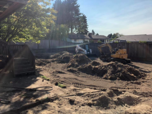 Backyard excavation and site preparation with dirt piles and equipment by M.C.Dirtworks in Caldwell, ID.