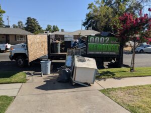 A backyard with old outdoor furniture, a grill, and other junk ready for removal by Haul-R-Us Junk Removal LLC in Fresno, CA.