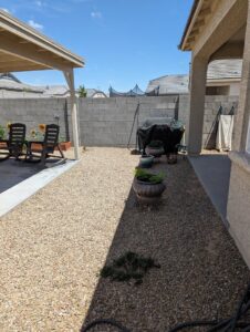 Backyard with gravel landscaping and a covered patio area by Centennial Builders, LLC in Litchfield Park, AZ.