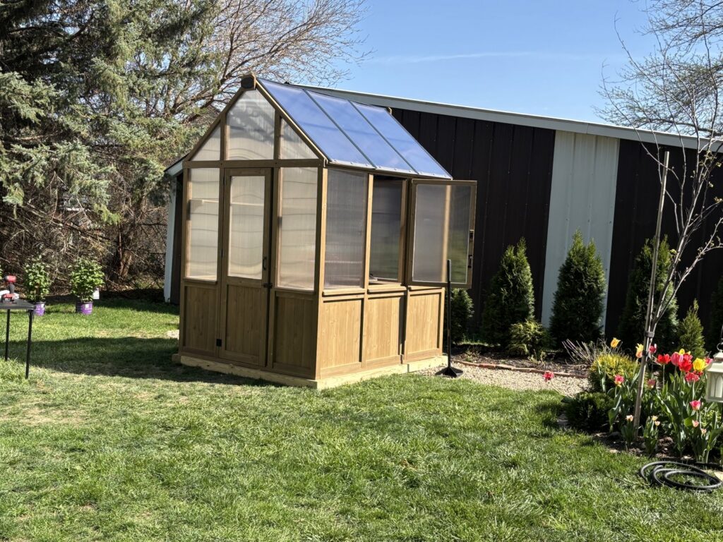 A newly assembled backyard greenhouse, demonstrating the assembly services of Dakota Small Jobs in Sioux Falls, SD.