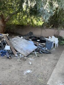 A large pile of mixed junk and debris in a backyard, ready for removal by New Haul Junk Removal in Los Angeles, CA.